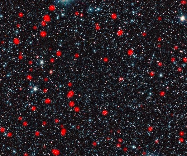 SMG, обнаруженные на фотографиях LABOCA, отмечены красным. Фоновый инфракрасный снимок был сделан космическим телескопом «<noindex><a target=_blank href=http://www.spitzer.caltech.edu/>Спитцер</a></noindex>». (ESO, APEX (MPIfR / ESO / OSO), A. Weiss et al., NASA Spitzer Science Center.) 